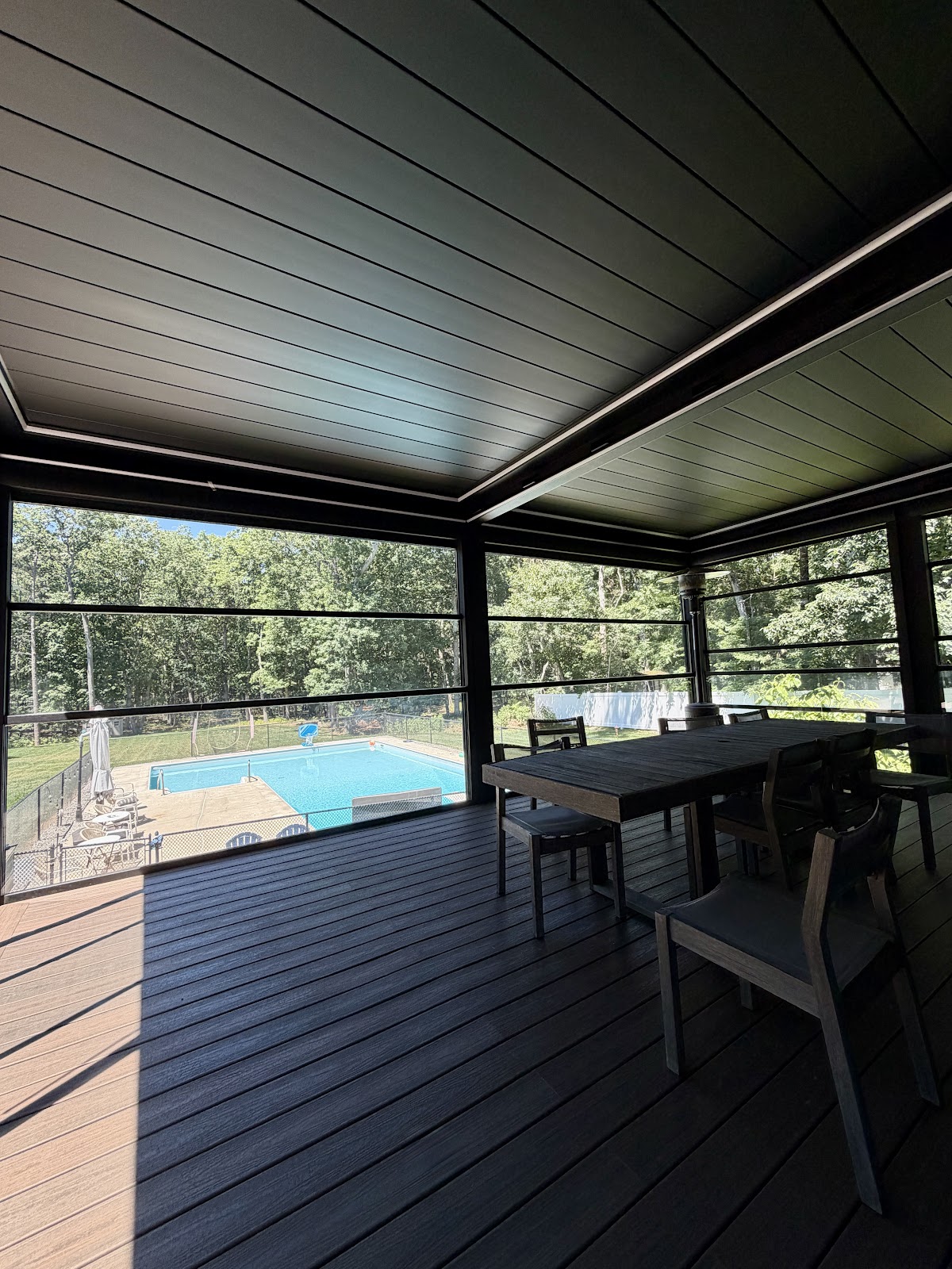 Dark pergola pool dining area