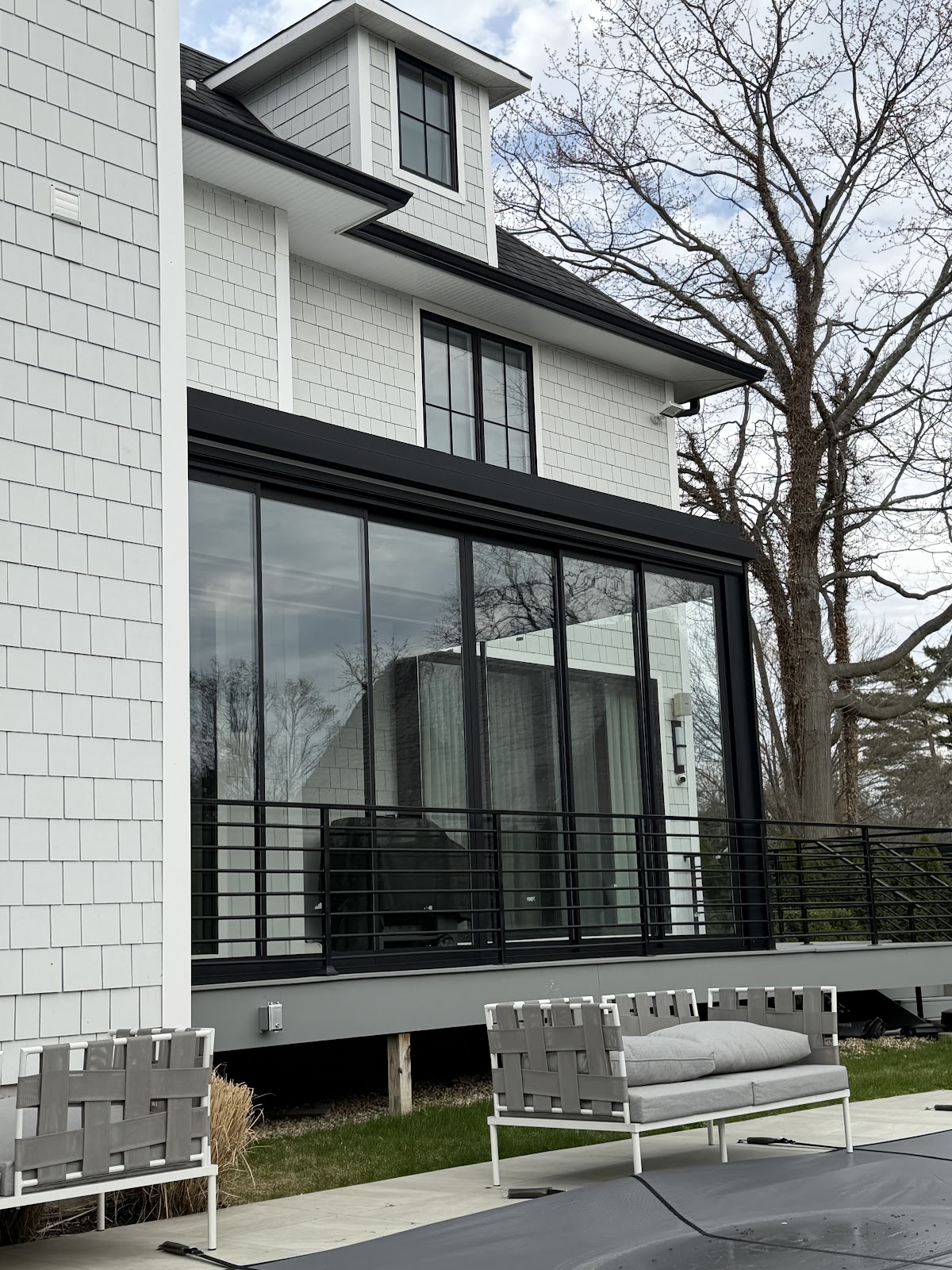 Shingle home with glass pergola addition